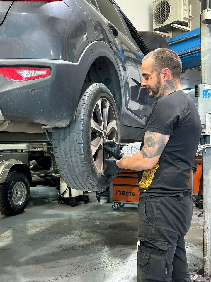 Mechanic fitting a wheel to a car